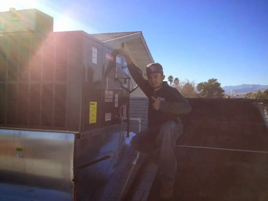 HVAC technician performing Boiler Repair on a rooftop unit in Rockwall